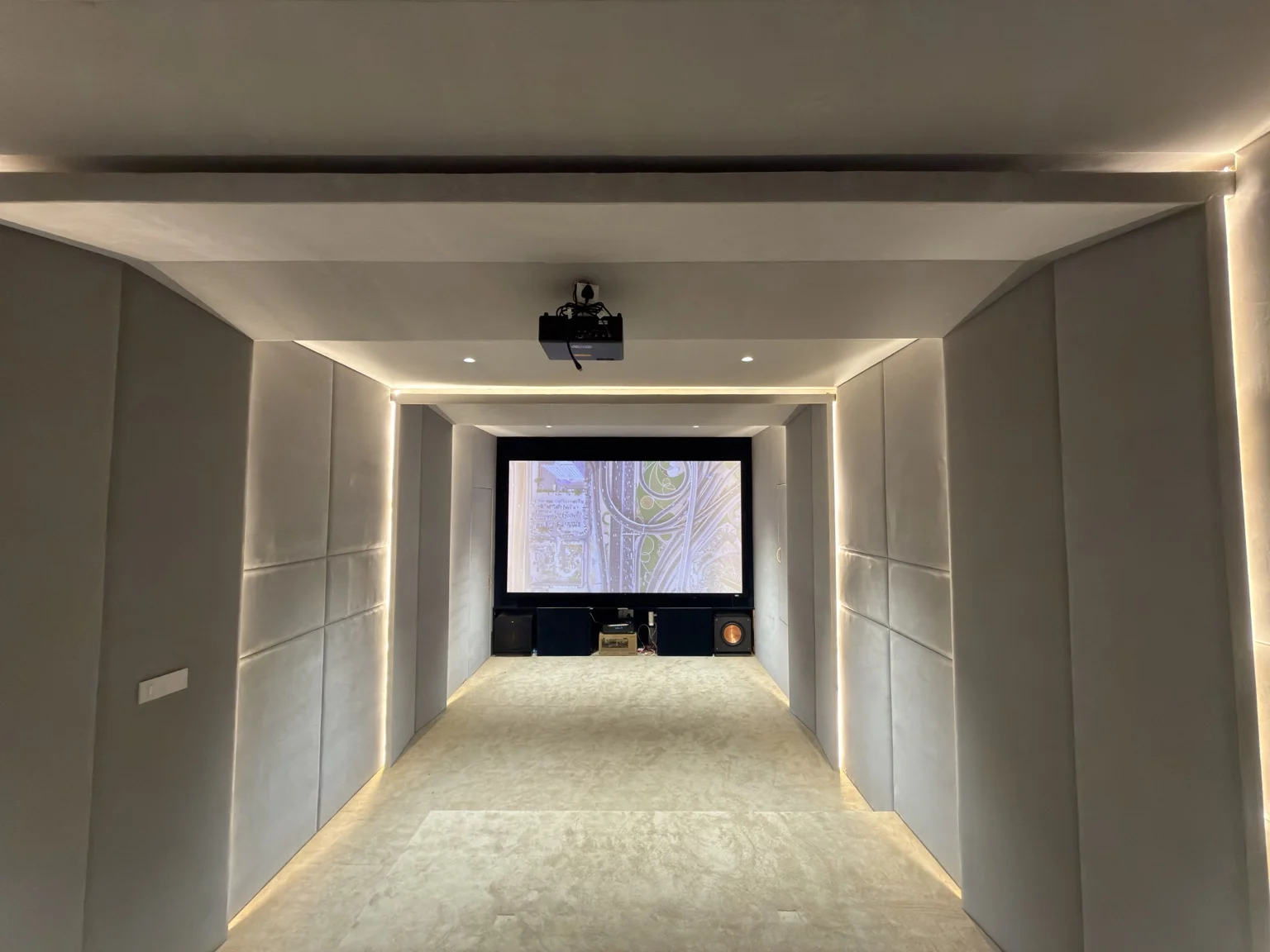 Long home cinema with acoustic panels and recessed lighting