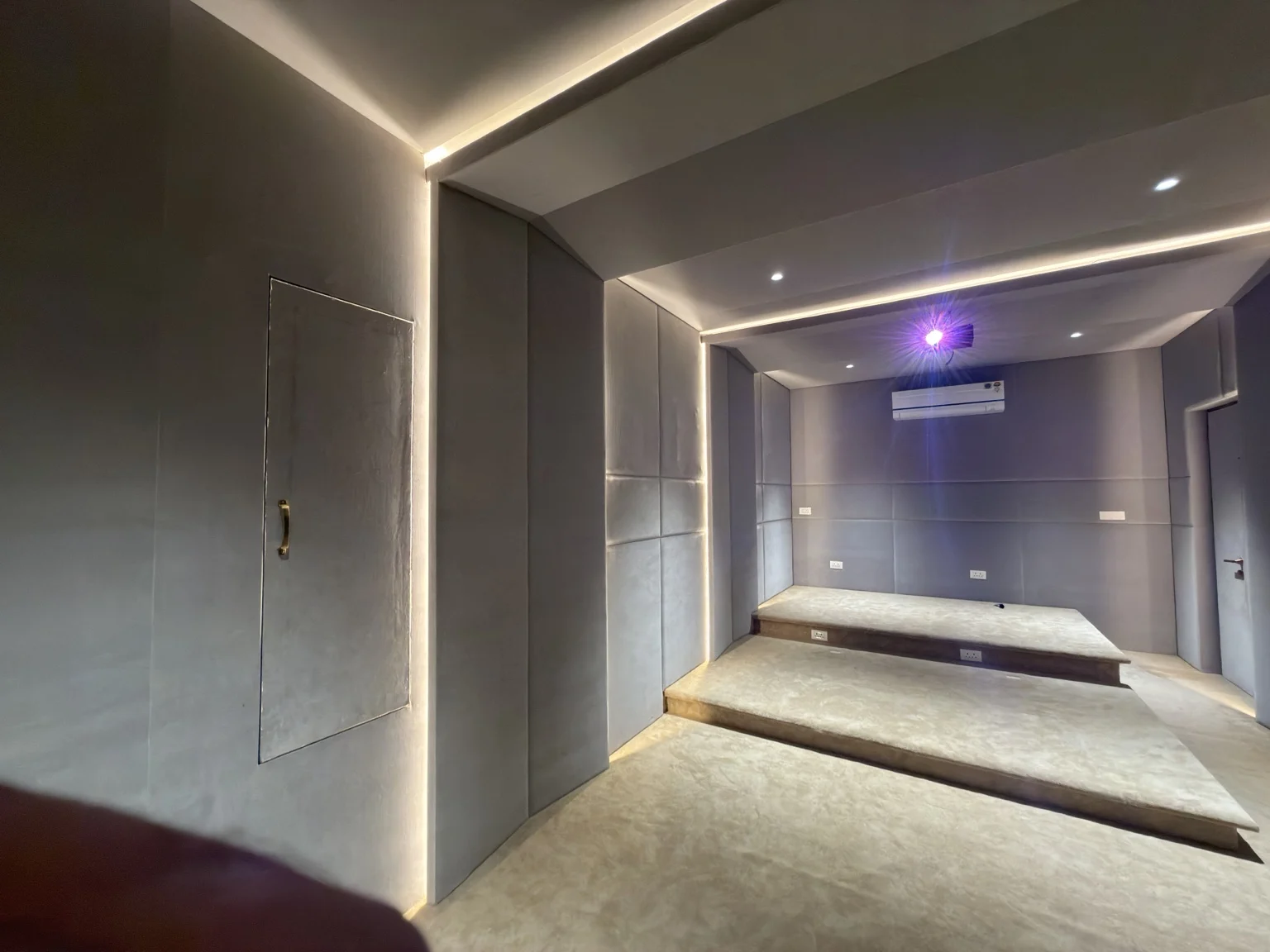 Cinema room showing raised seating platforms and integrated lighting